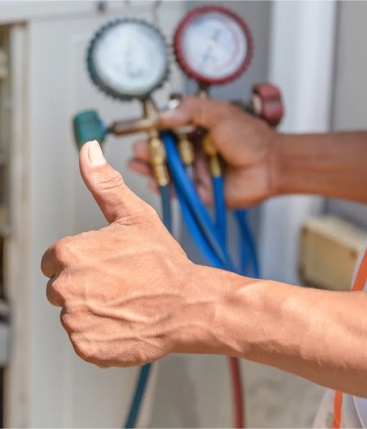 hvac-1 A person gives a thumbs up while holding HVAC gauges and colored hoses.